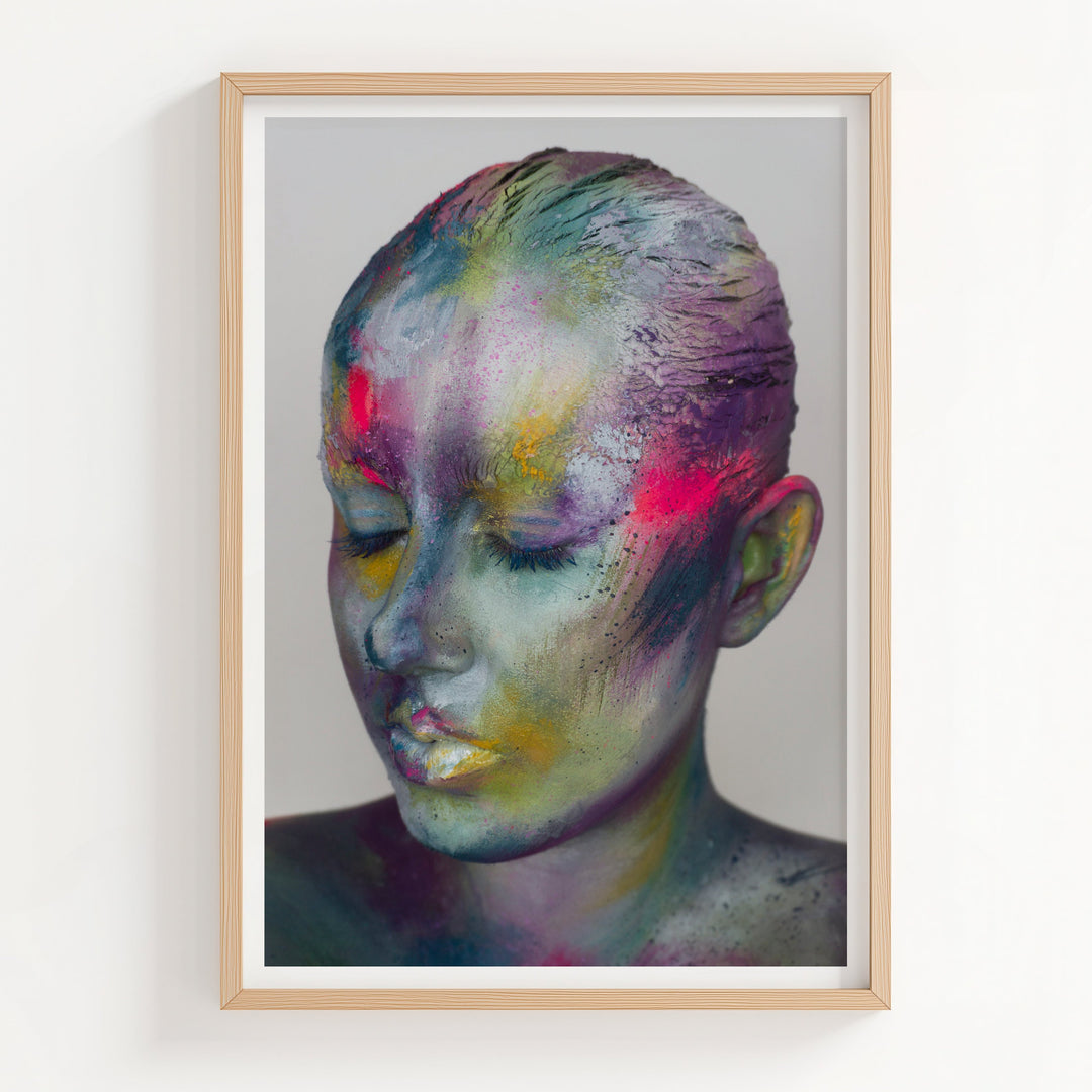 Framed artwork of a colorful abstract portrait on a white wall